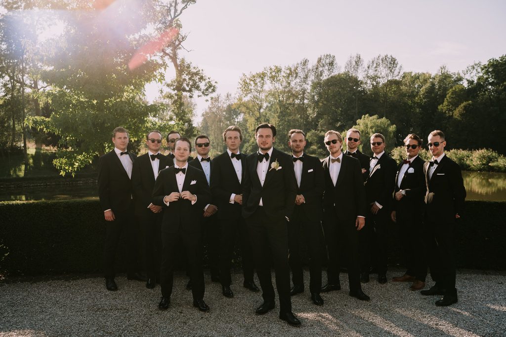 Stoere groepsfoto van de bruidegom en zijn vrienden tijdens golden hour in Chateau Bayard